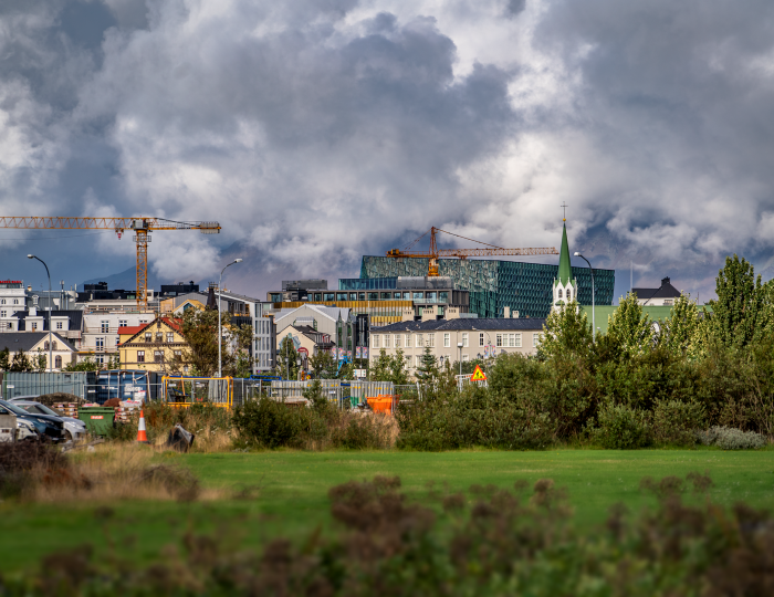 Construction cranes, green space and houses in Reykjavík.