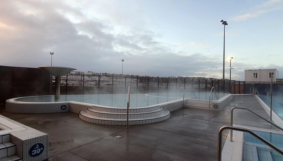 Séð yfir vaðlaugina út yfir Úlfarsárdal af bökkum Dalslaugar
