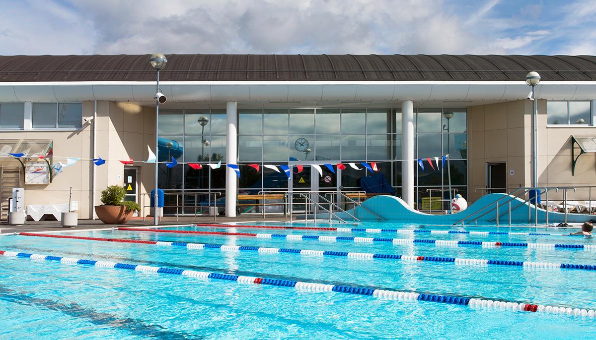 View across 25-meter pool toward indoor pool entrance at Grafarvogslaug