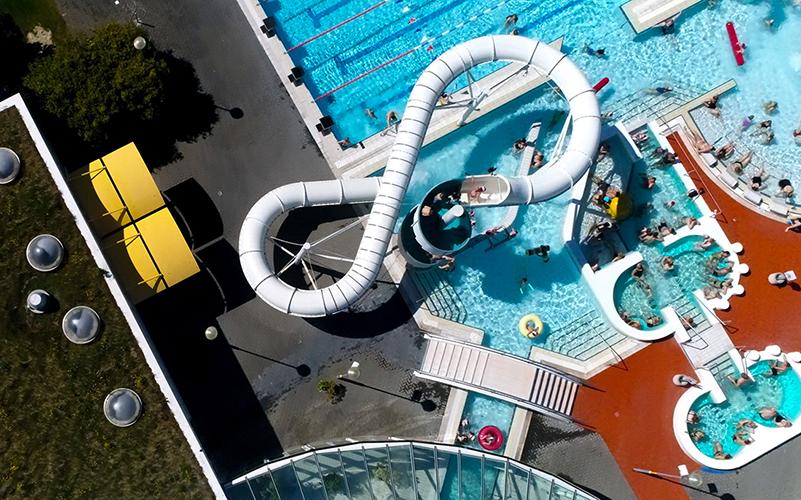 Aerial view of slide, hot tubs, and outdoor pool at Árbæjarlaug.