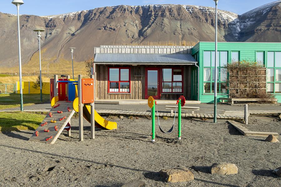 Leikskólinn Berg og leiktæki á lóðinni.