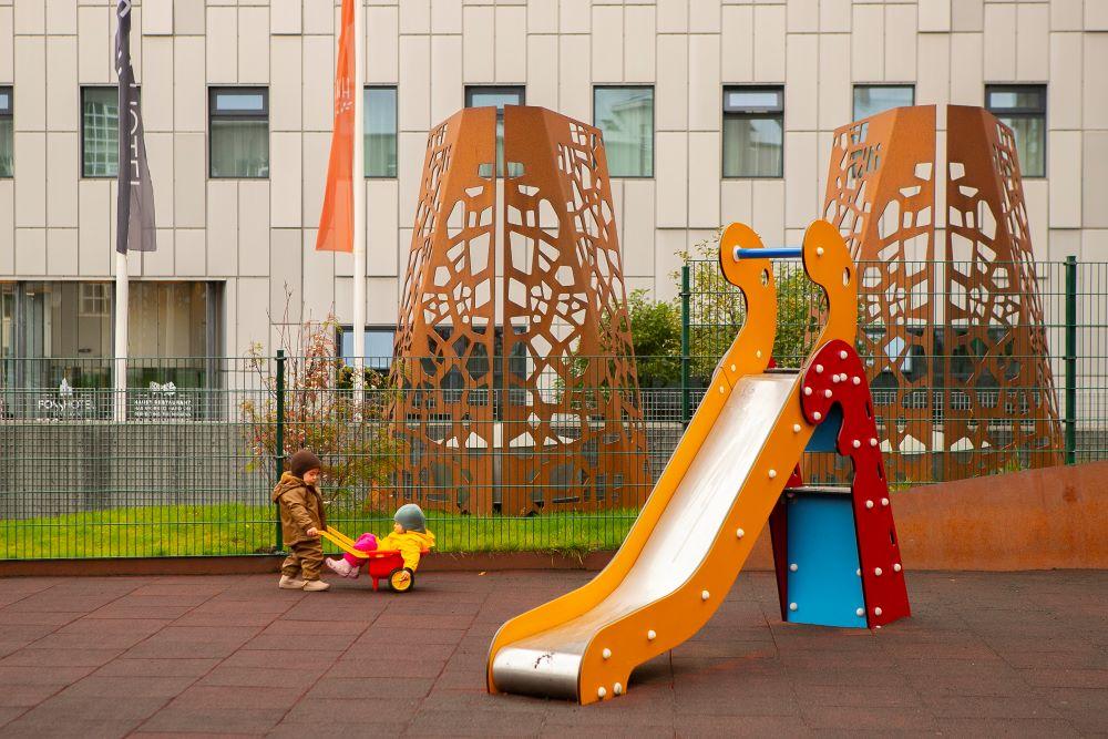 Children playing with playground equipment on the grounds of the nursery school at Bríetartún.