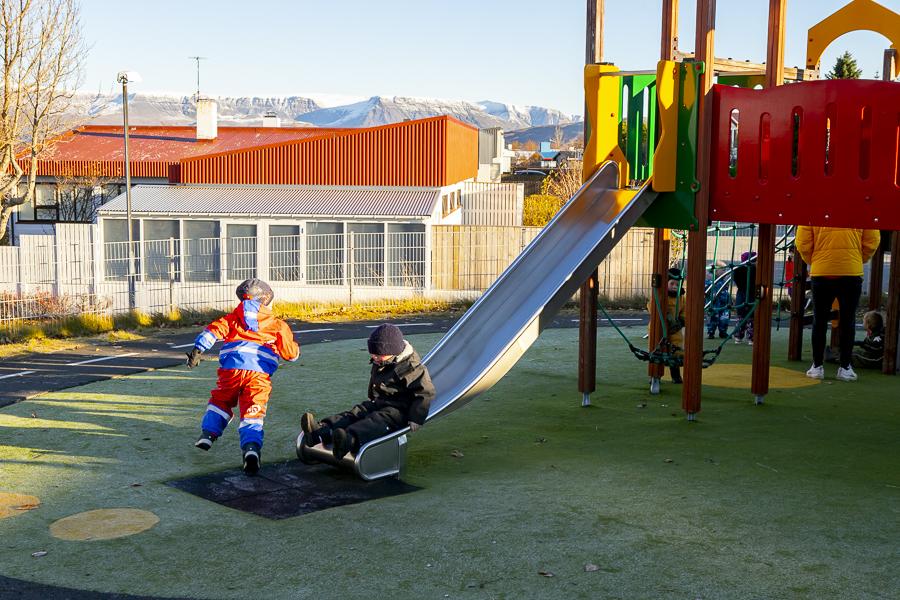 Children and playground equipment on Heiðarborg's grounds.
