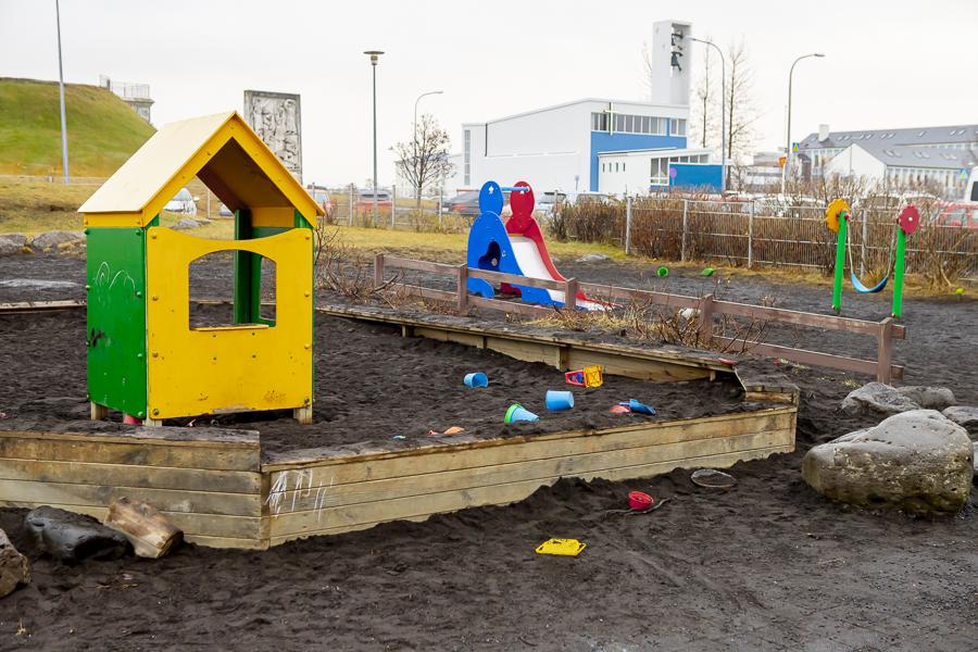 A sandbox, playhouse, and slide on the playground at Klambrar preschool.