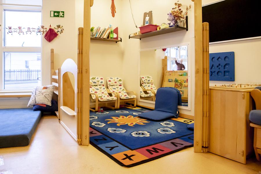 A cozy corner at Klambrar preschool with a rug, small armchairs, and a floor mat.