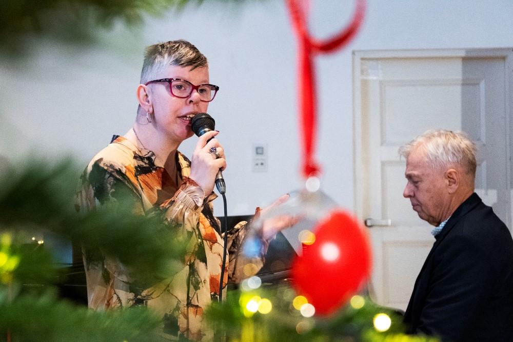 Steinunn Ása Þorvaldsdóttir syngur á afhendingu Kærleikskúlunnar 2022 í Listasafni Reykjavíkur. Á myndinni er líka jólatré með Kærleikskúlunni og píanóleikari.