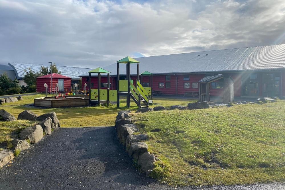 Leikkastali og lítið hús á útisvæði leikskólans Ness