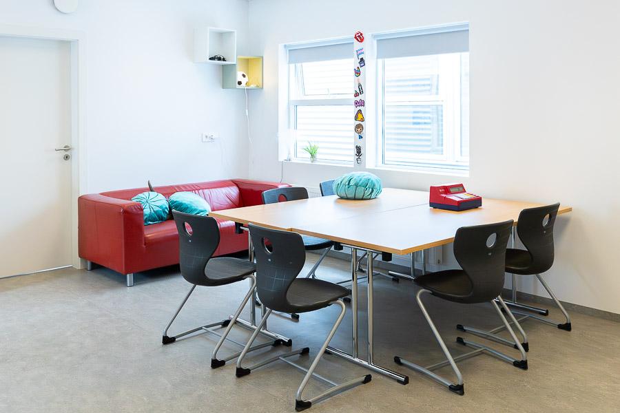 Room with red sofa, table and chairs. 