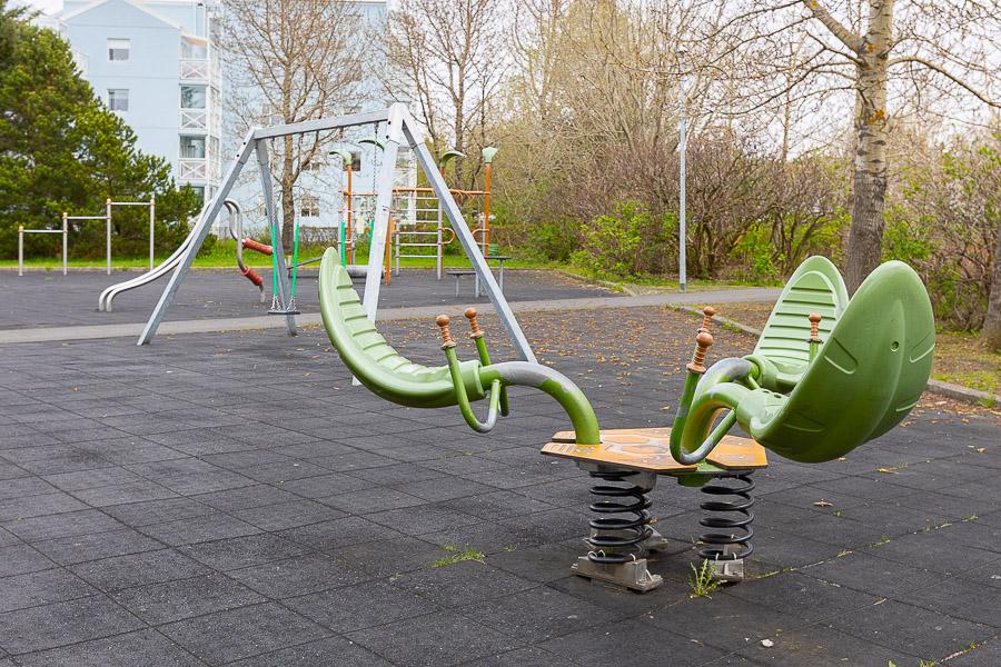Playground with swings and other playground equipment. 