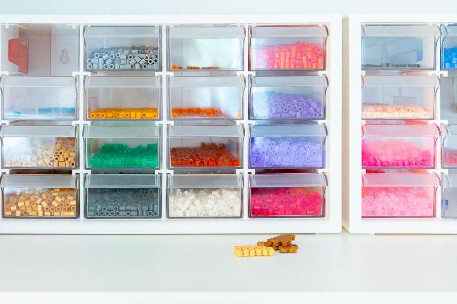 Small drawers filled with multicolored beads. 
