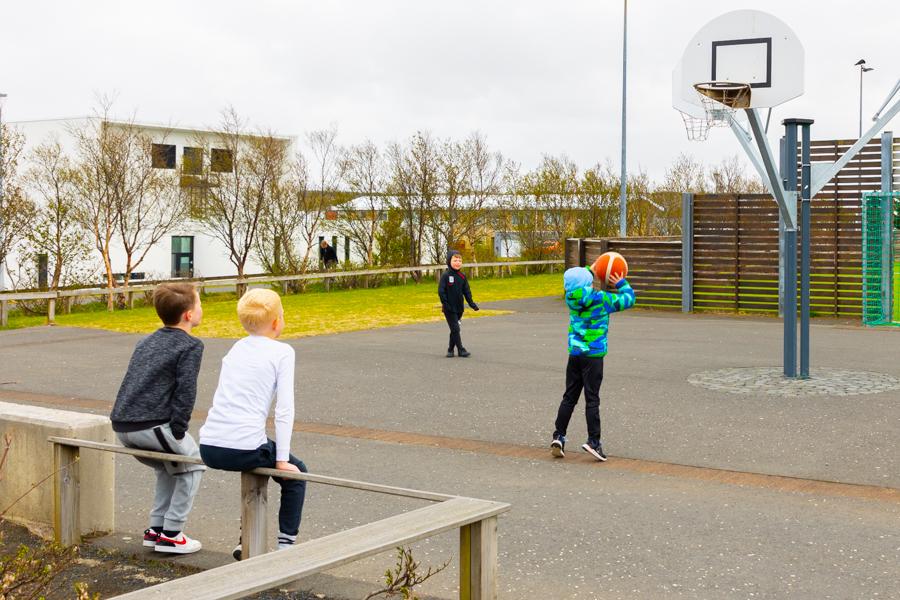 Children on a playground playing basketball.