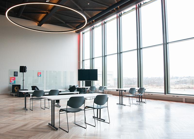 Photo of a large room at Hitt Húsið that's perfect for lectures and other events. Table and chairs. 
