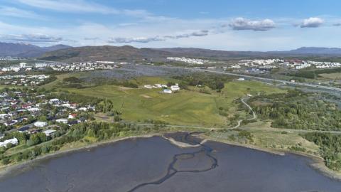 Yfirlitsmynd yfir Keldnaland, sjór, gras, tré, vatn og hús.