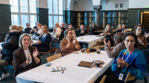 Fá málþingi um öryggi hinsegin fólks í Safnahúsinu 29.okt 2025. Fólk við borð í sal.